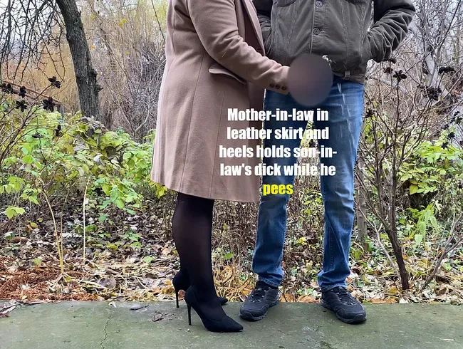 Schwiegermutter in Lederrock und High Heels hält Schwiegersohns Schwanz fest, während er pinkelt